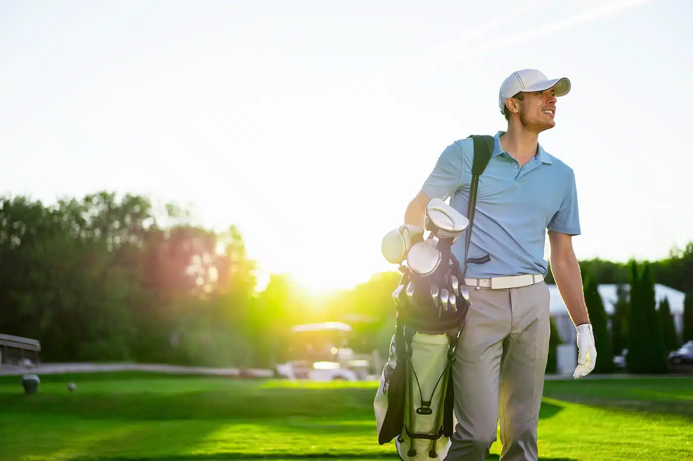 A man walking onto the golf course with no pain after seeing an orthopedic surgeon.