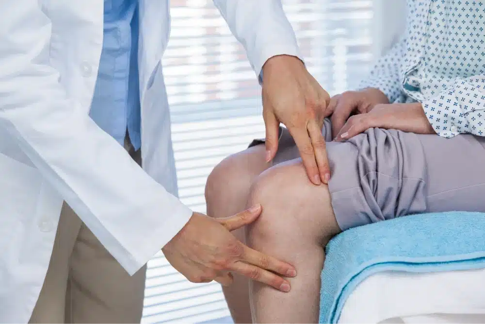 A doctor examines a patients knee looking for an acl tears or mcl tear.