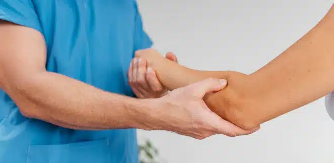 A patient recieves physical therapy on their outer elbow.